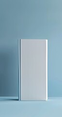 A blank hardcover book on a pale blue surface, shadows and a minimalist design
