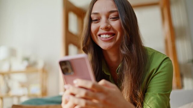 Home woman messaging smartphone sitting comfortably at soft couch. Smiling girl