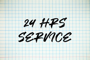 24hrs And 7 Day Service text written on white notebook sheet with grid