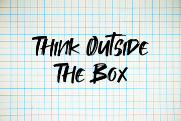 Think Outside The Box text written on white notebook sheet with grid