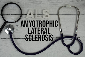 ALS Amyotrophic Lateral Sclerosis text with Stethoscope on wooden background