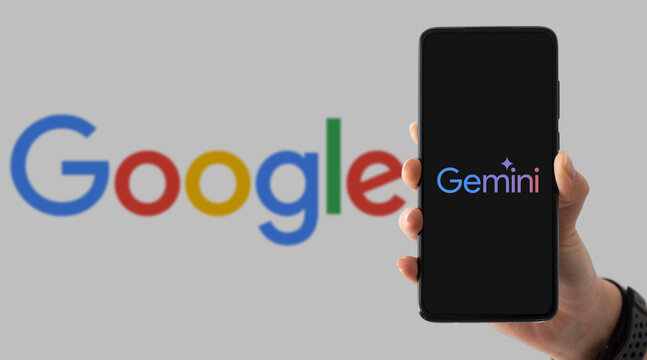 Hand holding smartphone with Google Gemini on screen