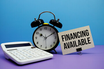 Financing Available text with calculator and alarm clock on blue and purple background