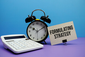 Formulating Strategy text with calculator and alarm clock on blue and purple background