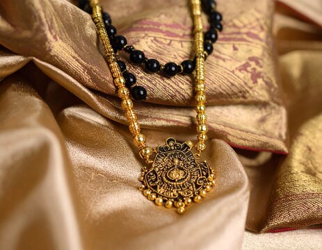 traditional Indian mangal sutra featuring glossy black beads and an intricate gold 