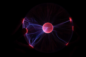 Plasma Ball with human hand causing plasma flow to jump to fingers creating unique patterns and textures