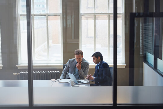 Men, thinking and laptop in glass office for meeting, legal procedure or lawyer team reviewing case. Attorney business, tech or discussion in firm for corporate law, trial planning or collaboration