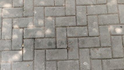 High-resolution photo of an interlocking paving block pattern, ideal for urban design backgrounds, construction presentations, or real estate marketing. Its symmetrical, clean texture fits architectur