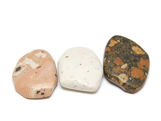Three rocks of different colors and sizes are displayed on a white background