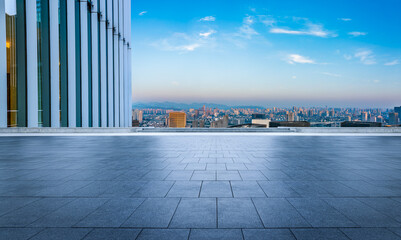 Empty square floor and modern city skyline under blue sky
