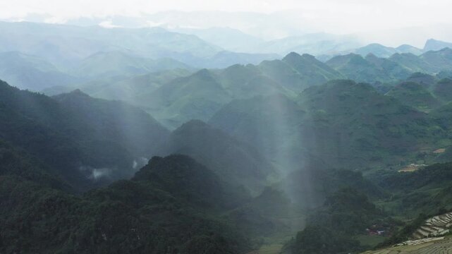 Wide aerial pull-out from the surging Dải Yếm (The Sash) Waterfall, identifying the moment a localized rain shaft saturates the surrounding terraced agriculture in Mộc Ch&acirc;u, Sơn La Province, Vietnam.