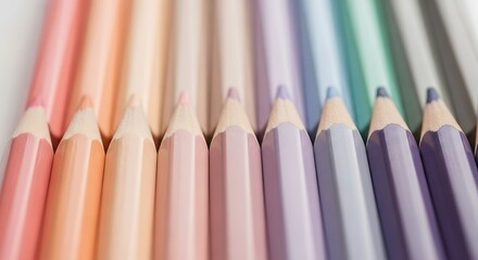 A closeup, shallow depth of field shot showcasing a row of colored pencils in soft, pastel shades arranged in a gradient