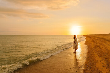 One Asian woman enjoying beautiful sunset on beach along Hainan Coastal Scenic Highway in Dongfang city, Hainan, China