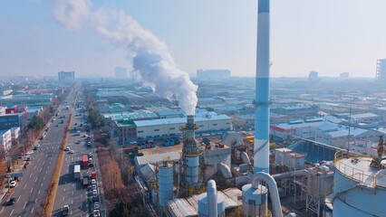 smoking chimney and busy road traffic in urban area, showcasing manufacturing, energy production, and environmental impact.