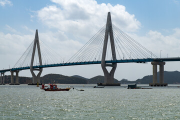 idyllic seascape with a suspension bridge and fishing boats