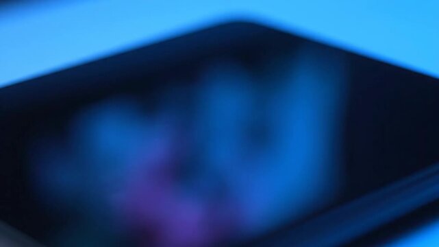 Close-up of tablet screen with blue light and digital design concept.