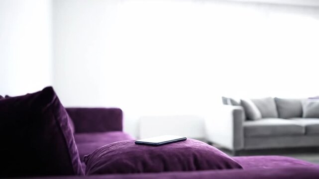 Modern smartphone lying on dark surface with screen reflecting purple light.