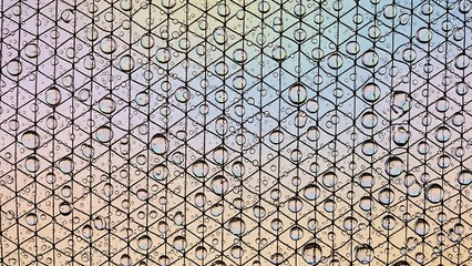 Rain droplets on a window with geometric pattern background