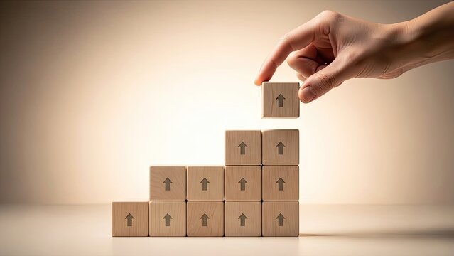 hand stacking wooden blocks with upward arrows representing growth and progress