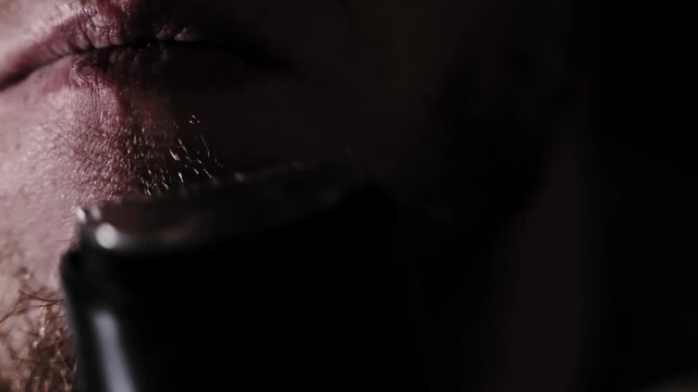 Electric shaver glides slowly creating dramatic contrast on male skin tone