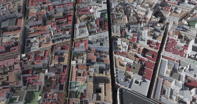 Top-down aerial drone view of C&aacute;diz residential rooftops and dense urban neighborhood, historic old town housing patterns, coastal Spanish city architecture, cinematic cityscape