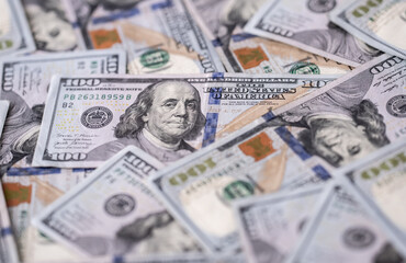 Money background with dollar bills. Texture of US dollars. 100 USD banknotes in focus. American hundred-dollars notes spread on a table. Pattern of US dollars for finance concept. Dollars currency.