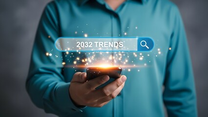 A man in a blue shirt searches for 2032 trends on a glowing smartphone