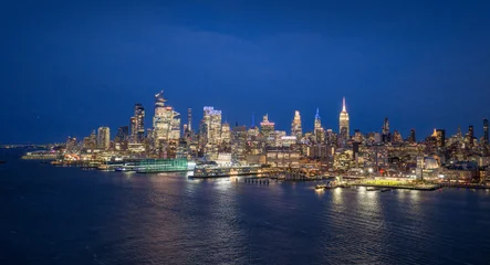Poster Manhattan New York City skyline with illuminated skyscrapers at night. New York panoramic cityscape with Hudson River view. NYC night skyline with Manhattan. New York City aerial view of downtown Manhattan.  © Volodymyr