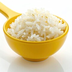 Close-up of cooked white rice piled in a yellow serving spoon on white