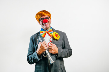 Smiling clown holding trumpet ready for performance