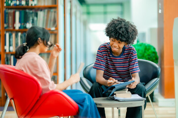 Library interior with students studying together using tablet showing digital education collaboration academic concentration environment.