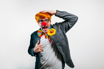 Mid adult man wearing clown costume experiencing surprise