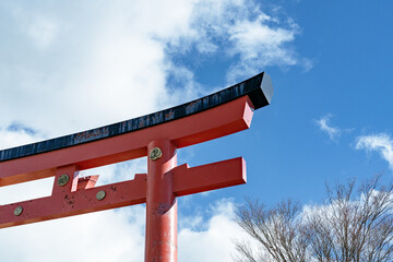 冬の青空に映える赤い鳥居 / Red torii gate against a crisp winter blue sky