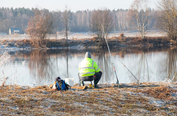 Fisherman on the river bank during sunset and catches fish with a spinning rod. Adult lifestyle.