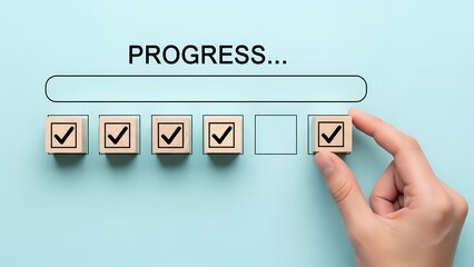 Hand placing a wooden block with a checkmark into a progress bar sequence indicating task completion and advancement