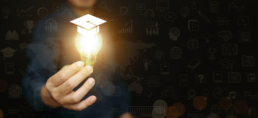 A man holding glowing lightbulb with graduation cap against educational icon background. Global education, knowledge, innovation, modern teaching, and the future of digital and online learning.
