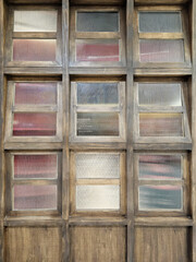 Wooden window frames with textured glass panes.