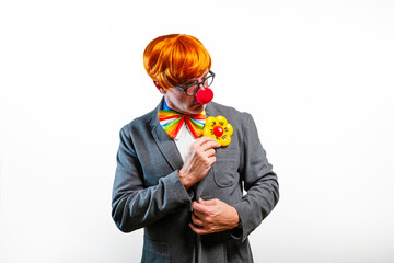 Clown businessman wearing colorful bowtie and red nose adjusting jacket