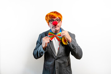 Businessman wearing clown costume with red nose and rainbow bowtie