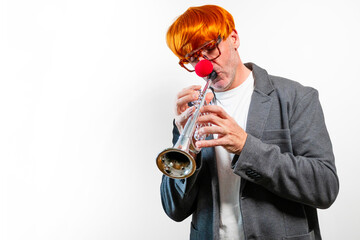 Man playing trumpet with clown wig and red nose