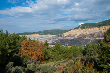 Panoramic aerial view of coal mine. Open pit mine industry, big yellow mining truck for coal quarry. Open coal mining anthracite mining. Pit on coal mining by open way. 
