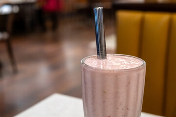 A glass of strawberry milkshake on the table