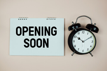 Opening Soon text with alarm clock on pink background