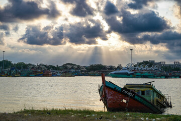 Obraz premium harbor scene featuring a derelict wooden shipwreck, illuminated by sunbeams