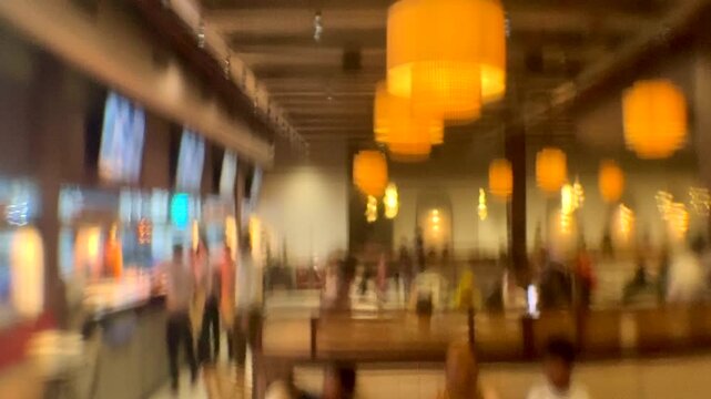 Interior scene of a restaurant viewed through fluted glass with vertical grooves, creating soft distortion and blurred movement