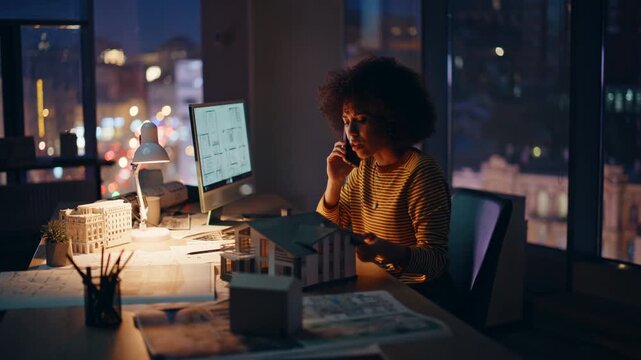 Stressed architect calling night office working on building project overtime.