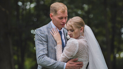 Newlywed couple embracing each other in a forest, celebrating their wedding day with love and tenderness