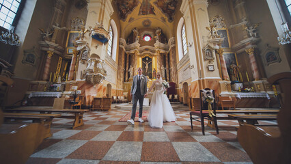 Newlywed couple walking down the aisle after exchanging vows in a beautiful church, marking the start of their married life
