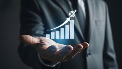 Businessman's hand holds up a glowing holographic bar chart with an upward arrow pointing towards a target symbol.