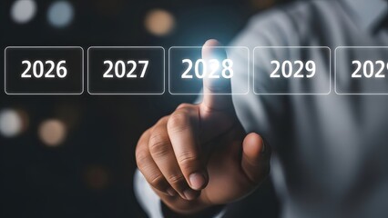 Businessman's hand points to the year 2028 on a futuristic digital interface, symbolizing future planning.